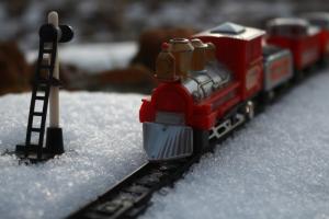 miniature red toy train with snow around